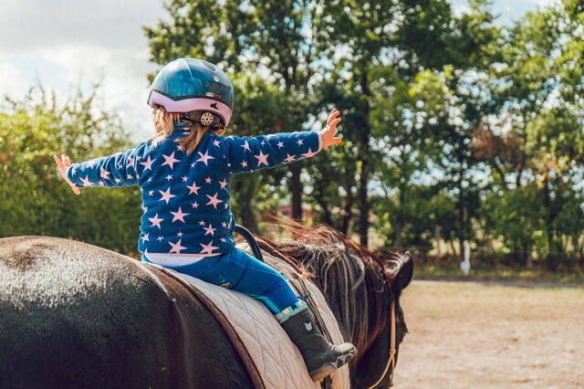 Una niña montando a caballo