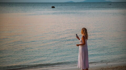 Mujer al teléfono en una playa