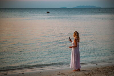 Mujer al teléfono en una playa